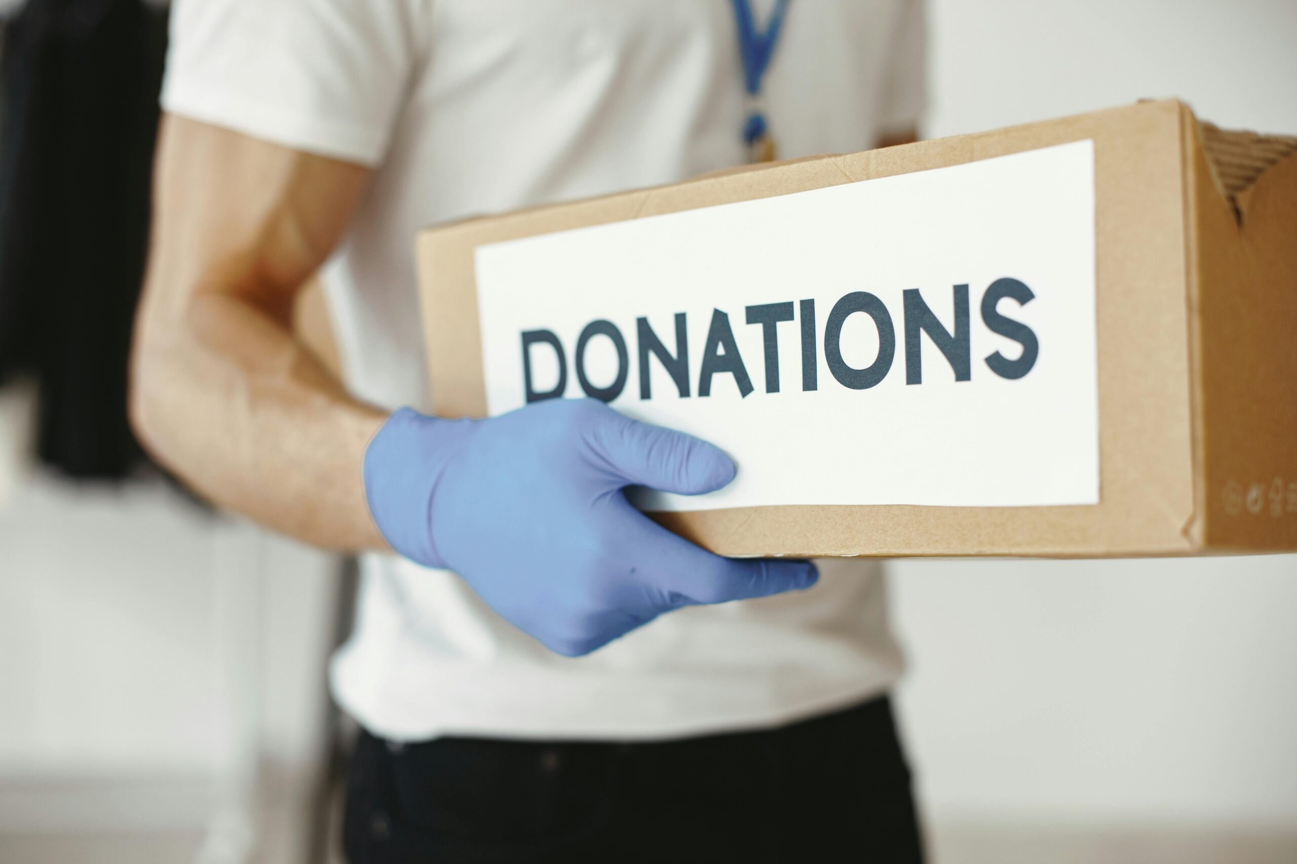 Donation pickup worker carrying a box of donated items