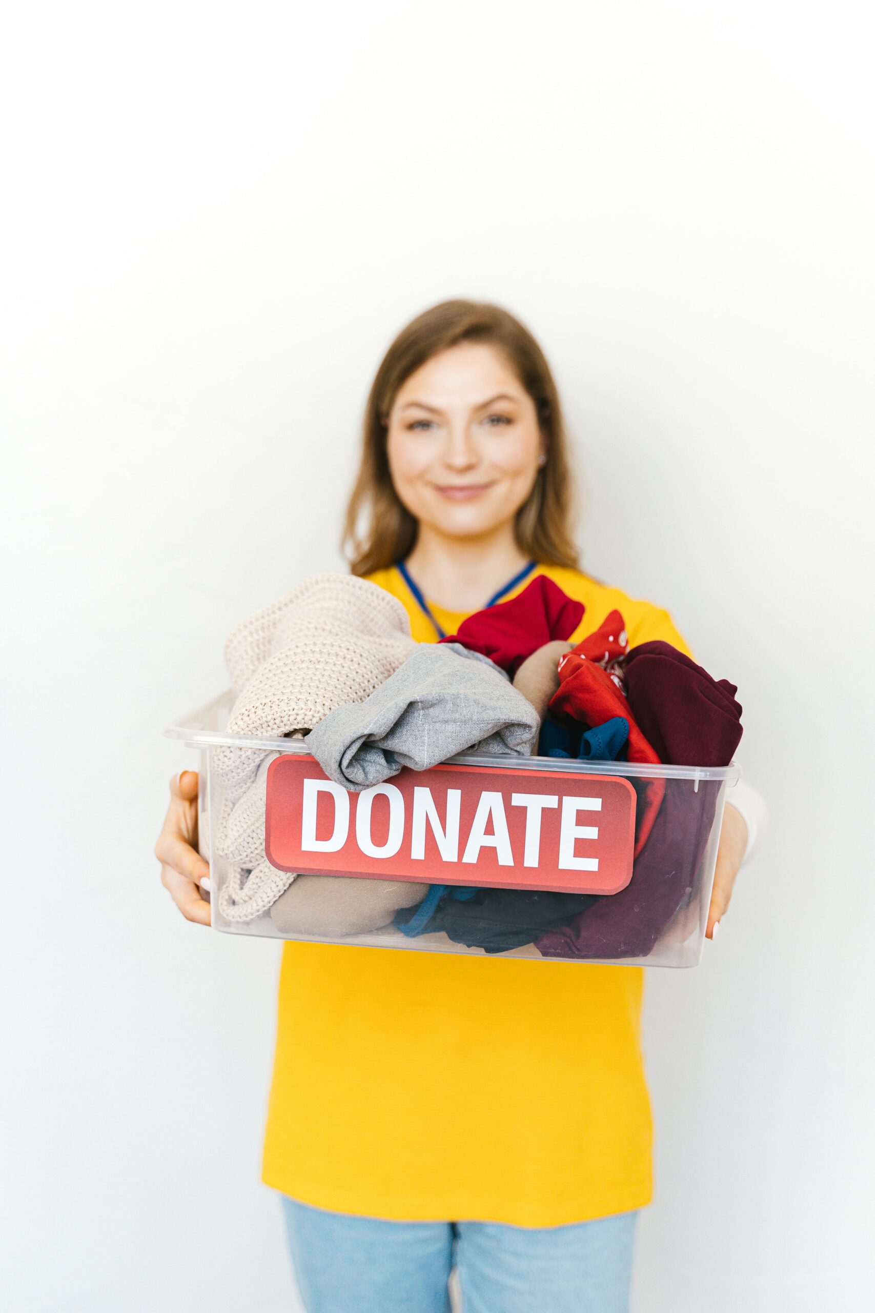Woman holding a container of clothing for donation pickup
